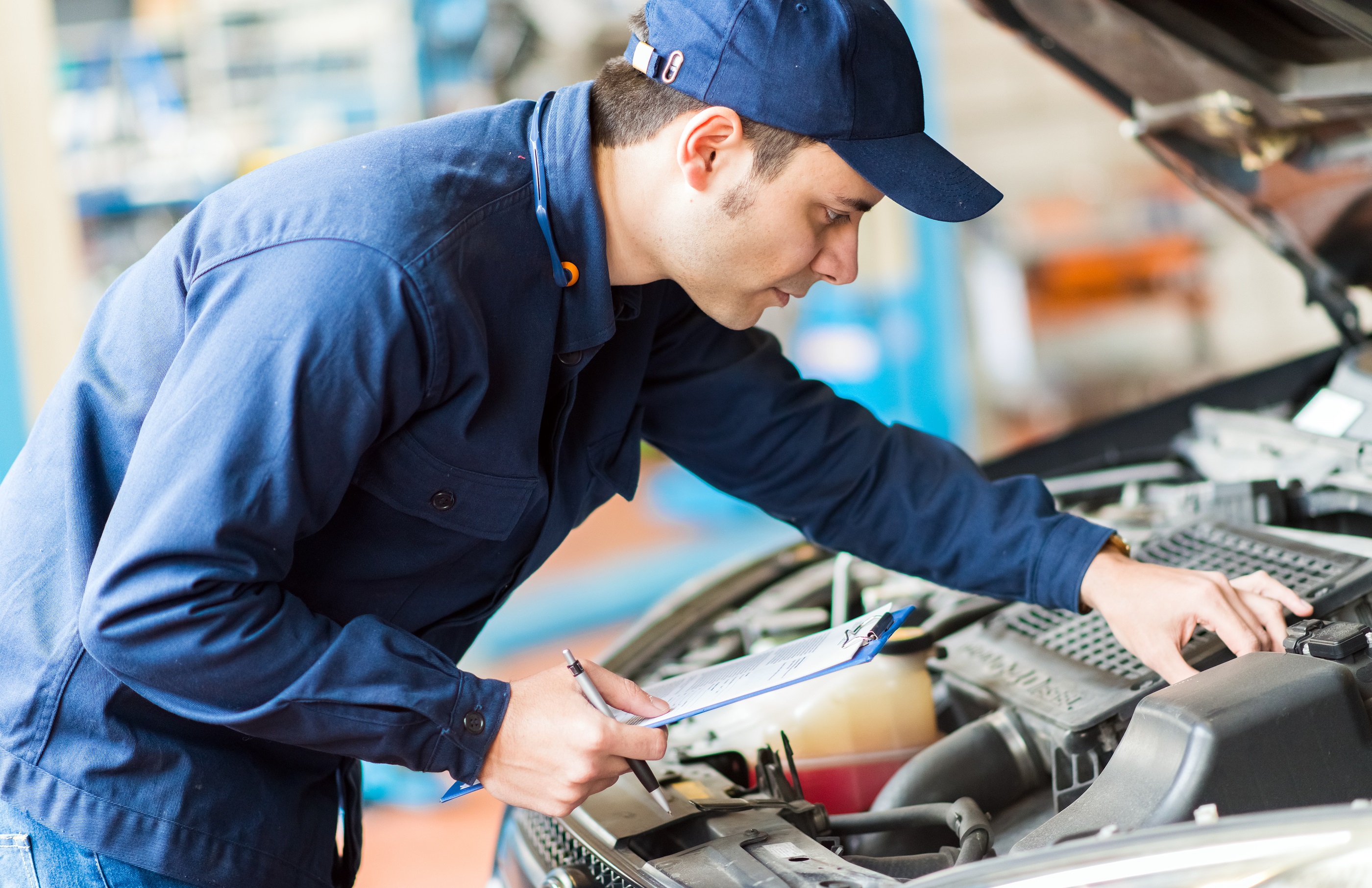 Mechanic inspecting engine and motor